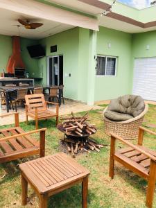 a patio with wooden benches and a fire pit at Refugio 4 suites com ar condicionado e piscina in Santa Bárbara do Rio Pardo