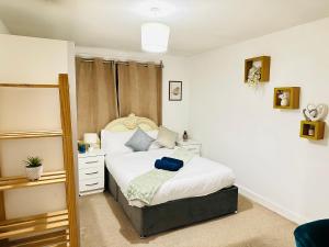 a bedroom with a bed with white sheets and a mirror at London NW Apartment in London