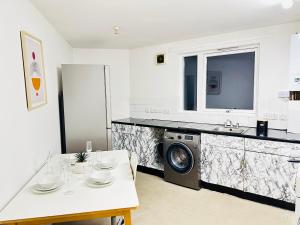 a kitchen with a washer and dryer and a washing machine at London NW Apartment in London