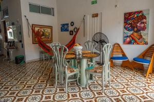 a dining room with a table and chairs and a painting at Hostal Badillo SV in Cartagena de Indias +65 photos