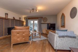 a living room with a couch and a tv at Cefn-Isaf in Llanbedr