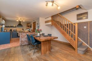 a kitchen and dining room with a wooden table and chairs at Cefn-Isaf in Llanbedr