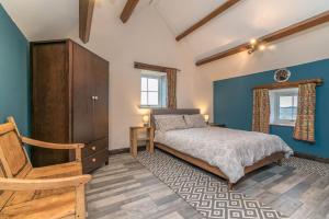 a bedroom with a bed and a wooden cabinet at Cefn-Isaf in Llanbedr