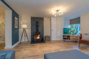 a living room with a fireplace and a television at Pwerdy in Betws-y-coed