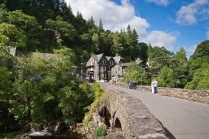 a group of people standing on a bridge over a road at Pwerdy in Betws-y-coed
