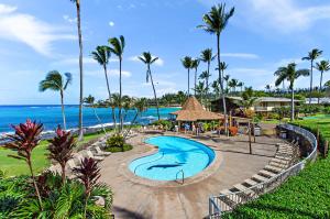 a pool at a resort with palm trees and the ocean at Napili Shores F145 in Kapalua