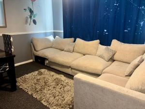 ein Wohnzimmer mit Sofa und blauen Vorhängen in der Unterkunft 2 Bed House-Sleeps 4-Free Parking in Coseley