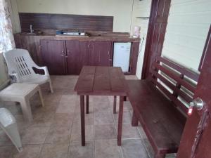 cocina con mesa de madera y nevera blanca en Buccaneer Resort, en Bocas Town