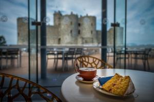 een tafel met een stuk cake en een kopje koffie bij Mehefin in Harlech