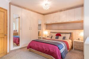 een slaapkamer met een groot bed en een spiegel bij Mehefin in Harlech