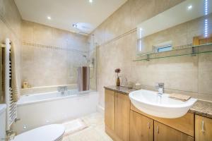 een badkamer met een wastafel, een bad en een toilet bij Mehefin in Harlech +26 foto's