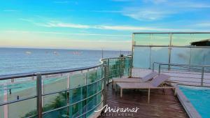 a balcony with two lounge chairs and the ocean at Manaíra Palace Residence-Prédio Beira Mar in João Pessoa