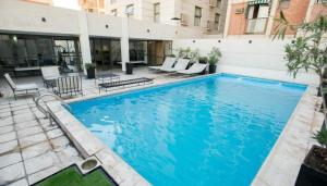 a large blue swimming pool in a building at Premium Apart centrico con Sauna, piscina y gimnasio in Mendoza
