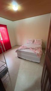 a bedroom with a bed and a red window at Casa Vale dos Peões Lumiar 3 in Nova Friburgo