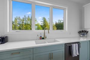 a kitchen with a sink and two windows at Dorcas Bay Dreams in Tobermory +64 photos