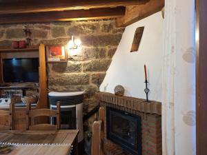 a living room with a fireplace and a tv at El Mirador del Alberche in Navaluenga +32 photos