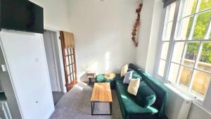 a living room with a green couch and a table at City Chic Stay in Bristol in Bristol