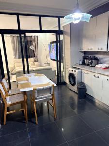 a kitchen and living room with a table and chairs at Haut Standing Appartement meublé Mamelles in Dakar