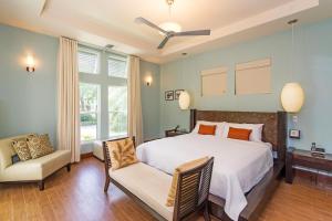 a bedroom with a large bed and a chair at Pomegranate Cottage in West Bay