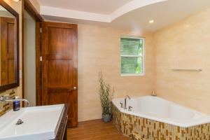 a bathroom with a large tub and a window at Pomegranate Cottage in West Bay