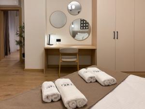 a bedroom with two towels on a bed with a mirror at Soho Suites Skopje City Centre - Luxury Apartments in Skopje