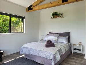 a bedroom with a large bed in a white room at Whangaroa Casa Roca Studio in Whangaroa
