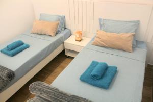 two beds in a room with blue pillows on them at My Boavista 2 in Sal Rei