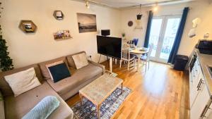 a living room with a couch and a tv and a table at Urban Oasis Stylish Boho Flat in Bristol in Bristol