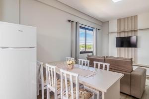 a kitchen and living room with a table and a couch at CTDs - Apartamentos no Centro de Penha! in Penha