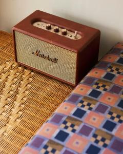 une radio marron posée à côté d'un lit dans l'établissement Bayay Tamsi, à General Luna