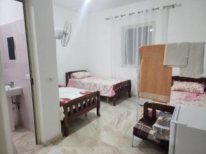 a bathroom with two beds and a mirror at Bujtina Ismet Gjeli 
