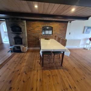 a dining room with a table and a brick wall at Holiday In A Cozy Farmhouse With Horses in Bøvlingbjerg