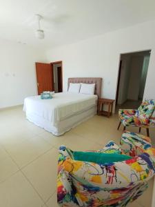 ein Schlafzimmer mit einem Bett, einer Couch und einem Stuhl in der Unterkunft Buzios casa porto da barra in Búzios