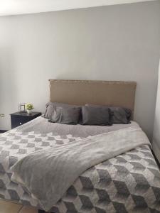 a bedroom with a bed with a gray and white comforter at Departamento Tlaxcala #3 in Ciudad Obregón