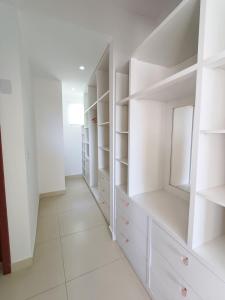 einen weißen begehbaren Kleiderschrank mit weißen Regalen in der Unterkunft Buzios casa porto da barra in Búzios