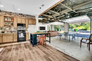 a large kitchen with wooden cabinets and tables and chairs at Flint Palestine Lakefront Retreat Firepit BBQ in Flint