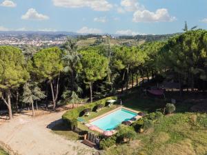 Una vista aérea de una piscina en una colina con árboles. en Bugnolo Miniloft, en Poggibonsi