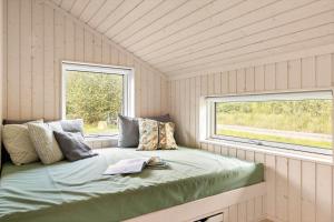 Bett in einem kleinen Zimmer mit Fenster in der Unterkunft 6757 Hasle - Skovtoften 16 in Hasle