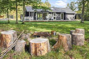 eine Gruppe von Baumstumpfen vor einem Haus in der Unterkunft 6757 Hasle - Skovtoften 16 in Hasle