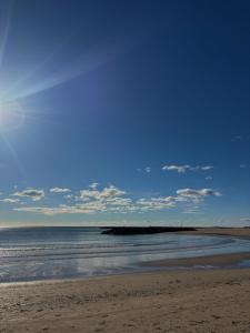 a beach with a blue sky and the ocean at À 1min à pied de la mer, studio lumineux & cosy in Carnon-Plage +8 photos