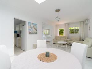 a white living room with a white table and chairs at FaroQuilla Suites Pasito Blanco in Pasito Blanco