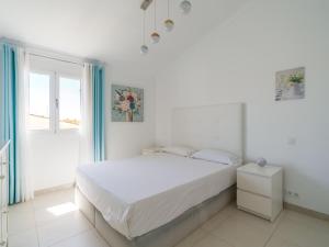 a white bedroom with a bed and a window at FaroQuilla Suites Pasito Blanco in Pasito Blanco +42 photos
