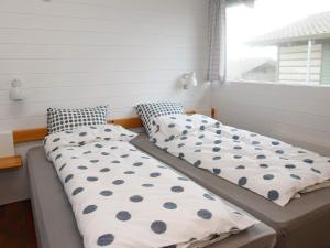 two beds sitting next to a window in a room at Vigsø Holiday Center- Type 7 in Hanstholm +19 photos