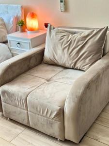 a couch in a living room with a table at Cozy studio with a balcony and sea view in Batumi