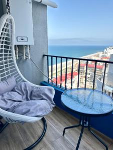 a room with a hammock and a table and a balcony at Cozy studio with a balcony and sea view in Batumi