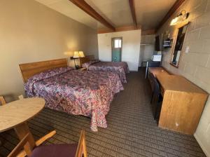a hotel room with two beds and a table at Economy Inn in Elko