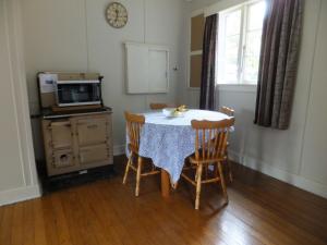 a kitchen with a table with chairs and a microwave at 29 Jollies Pass Road in Hanmer Springs