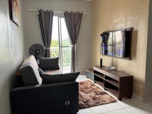 Una sala de estar con un sofá y un televisor. en Apartamento Completo em Belém - Stay in comfort just minutes from COP30, en Belém