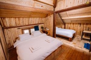 a bedroom with a large bed in a wooden cabin at TVpalm Ecolodge in Ha Giang +97 photos