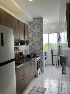 cocina con nevera y suelo de baldosa. en Apartamento Completo em Belém - Stay in comfort just minutes from COP30, en Belém